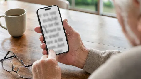Hands holding a phone with large text on the screen